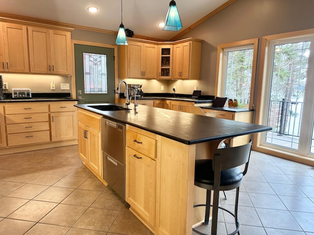 kitchen featuring light tile patterned floors, dark countertops, stainless steel dishwasher, light brown cabinets, and a sink