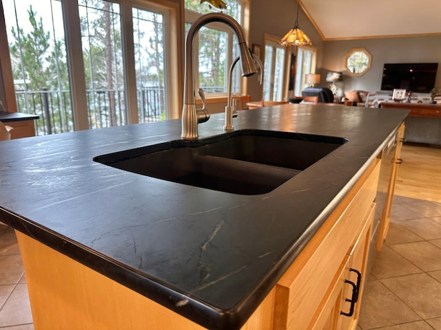 kitchen with dark countertops, open floor plan, a sink, and lofted ceiling