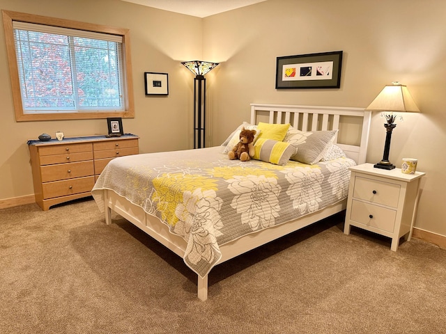 bedroom featuring light colored carpet and baseboards