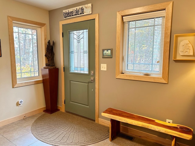 doorway to outside featuring tile patterned floors, visible vents, and baseboards