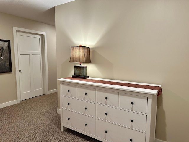 hall featuring carpet flooring and baseboards