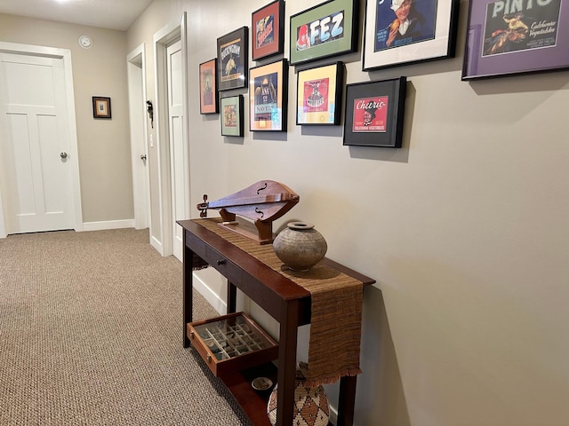 corridor with baseboards and carpet flooring