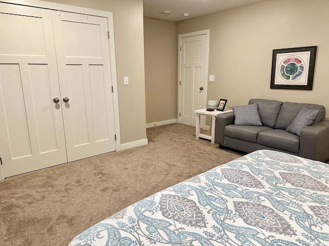 bedroom with a closet, light carpet, and baseboards