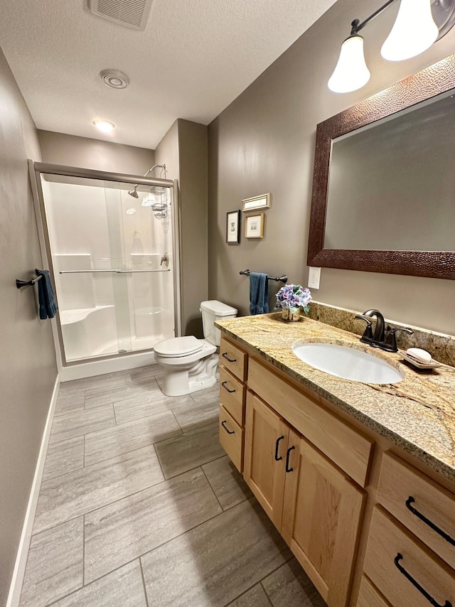 full bathroom featuring visible vents, toilet, wood tiled floor, a textured ceiling, and a shower stall