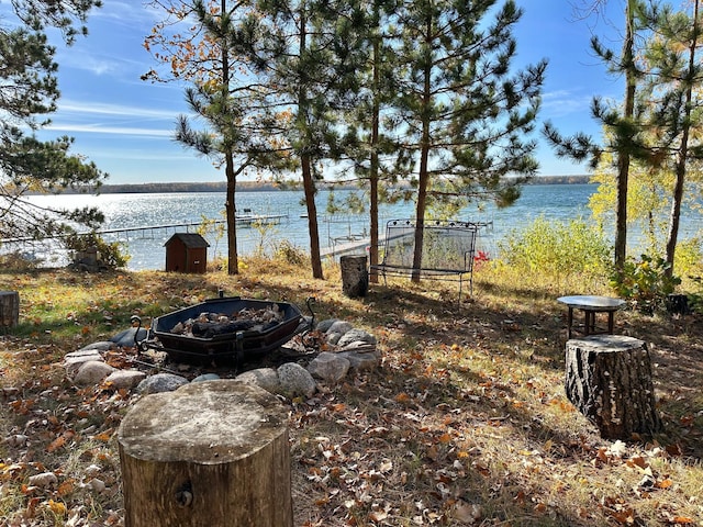 view of yard with an outdoor fire pit and a water view