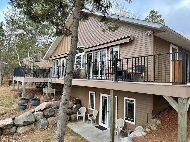 rear view of property featuring a patio area and a deck