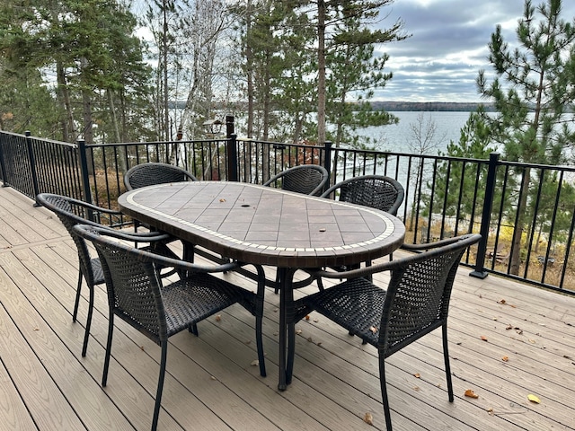 wooden deck with outdoor dining space and a water view