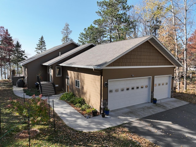 view of front facade featuring a garage and aphalt driveway