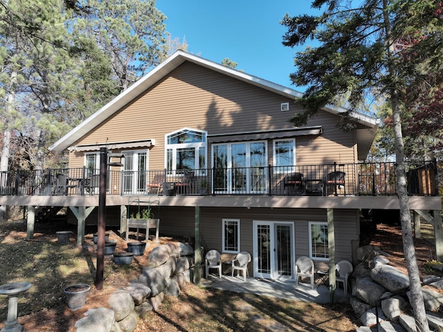 rear view of house featuring french doors, a patio, and a deck