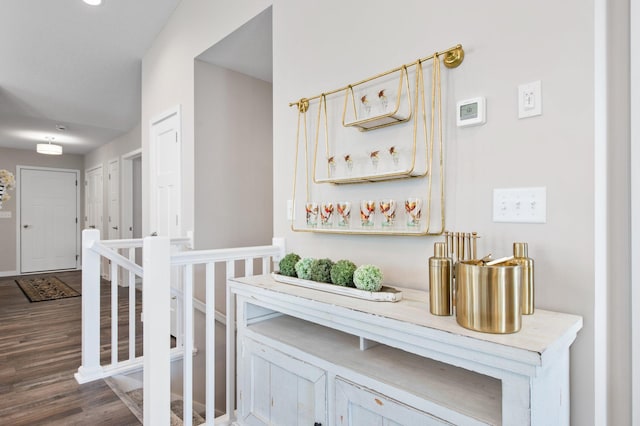 hall featuring an upstairs landing and wood finished floors