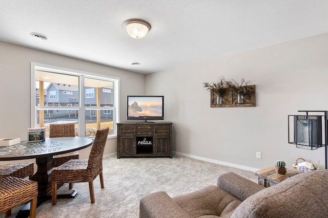 carpeted dining space featuring visible vents and baseboards