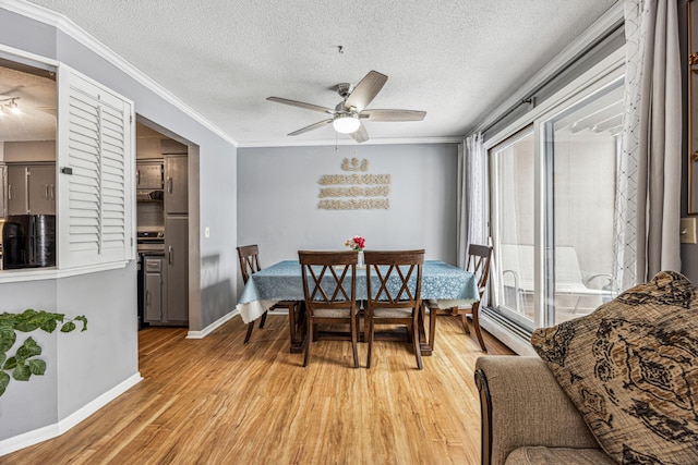 dining space with ceiling fan, light wood finished floors, a textured ceiling, and crown molding