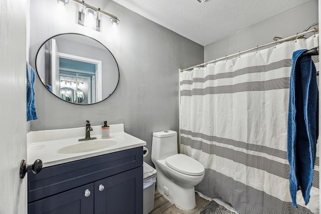 bathroom with toilet, a shower with curtain, a textured ceiling, and vanity