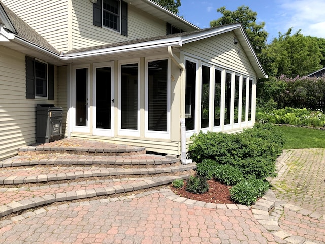 entrance to property featuring a shingled roof