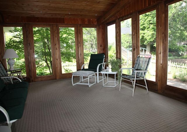 sunroom / solarium featuring a wealth of natural light, wooden ceiling, and vaulted ceiling