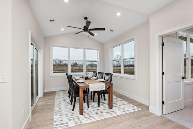 dining space with vaulted ceiling, plenty of natural light, baseboards, and light wood-style floors