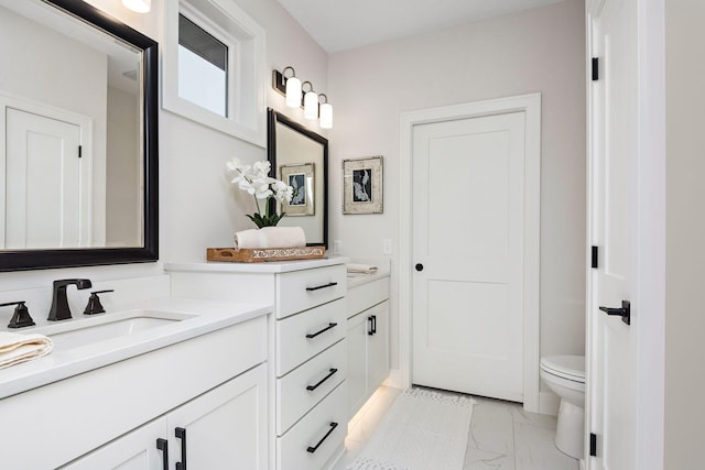 bathroom featuring marble finish floor, vanity, and toilet