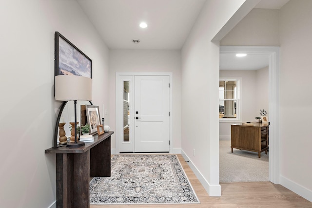 entryway featuring light wood finished floors, baseboards, and recessed lighting