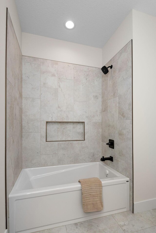 full bath featuring a textured ceiling, tile patterned flooring, and shower / tub combination