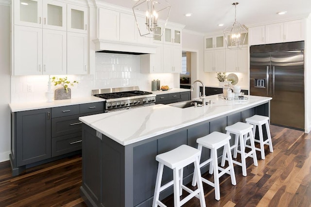 kitchen with backsplash, a chandelier, high end appliances, and a sink