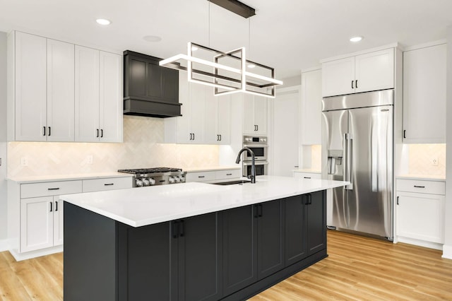 kitchen featuring light countertops, appliances with stainless steel finishes, a sink, and white cabinets