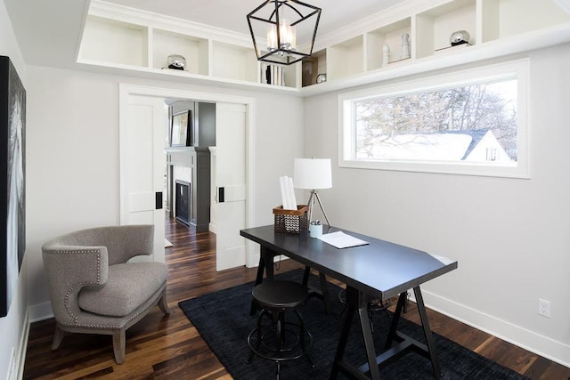 office space with a fireplace, baseboards, a chandelier, and dark wood-style flooring