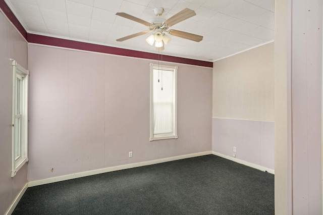 carpeted empty room with ornamental molding, ceiling fan, and baseboards