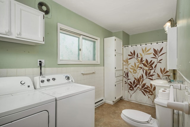 laundry room with a baseboard heating unit, laundry area, visible vents, tile walls, and independent washer and dryer