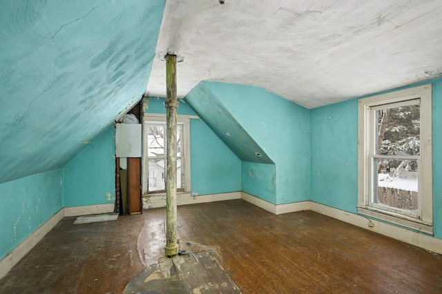 additional living space with vaulted ceiling, baseboards, and wood finished floors