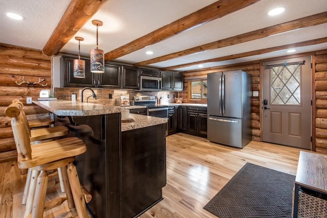 kitchen featuring a breakfast bar, decorative light fixtures, a peninsula, stainless steel appliances, and light wood-style floors