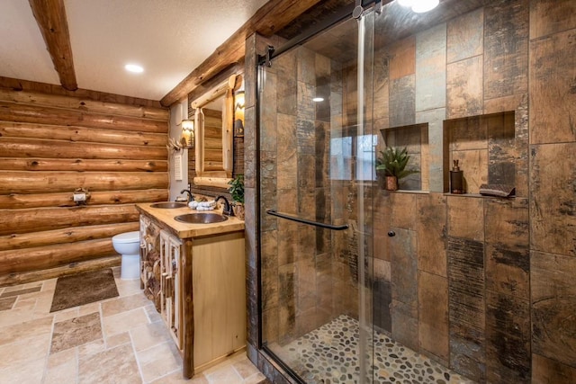 bathroom with toilet, vanity, a shower stall, beam ceiling, and stone tile flooring