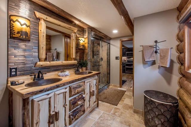 full bathroom featuring tasteful backsplash, a stall shower, a sink, and stone tile floors