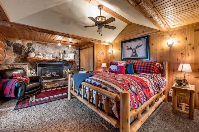 carpeted bedroom featuring wooden walls, wood ceiling, a stone fireplace, and lofted ceiling with beams