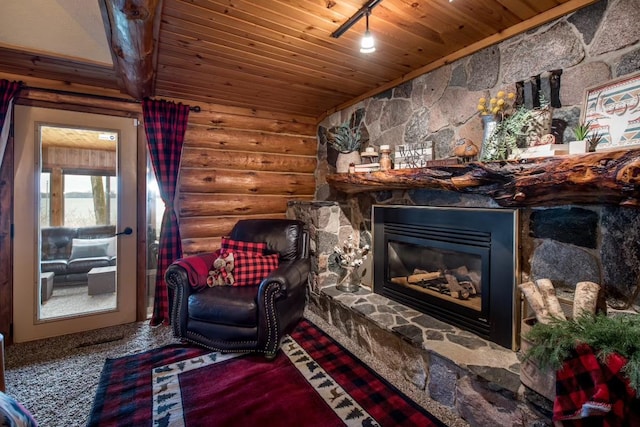 sitting room with wood ceiling, rustic walls, and a stone fireplace