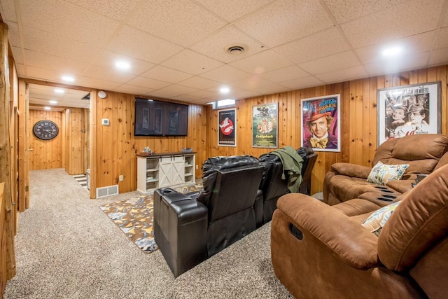 home theater room featuring wood walls, visible vents, and carpet flooring