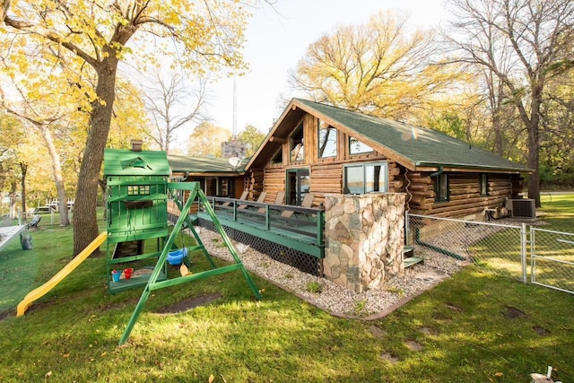 view of play area featuring a yard, a gate, fence, a deck, and cooling unit