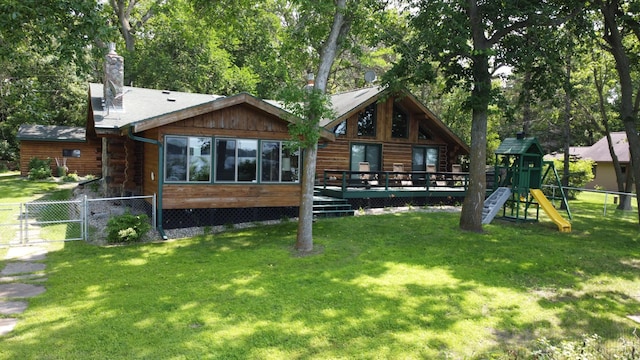 back of property featuring a lawn, a playground, and a gate