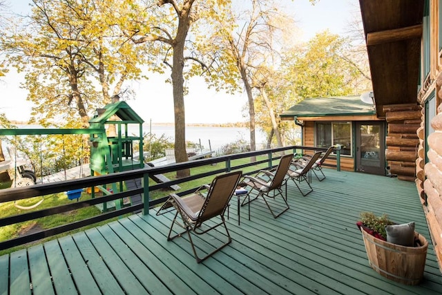 deck with a playground and a water view