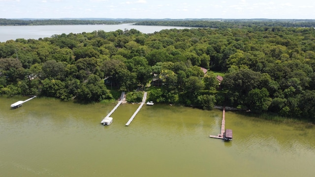 birds eye view of property with a water view and a wooded view