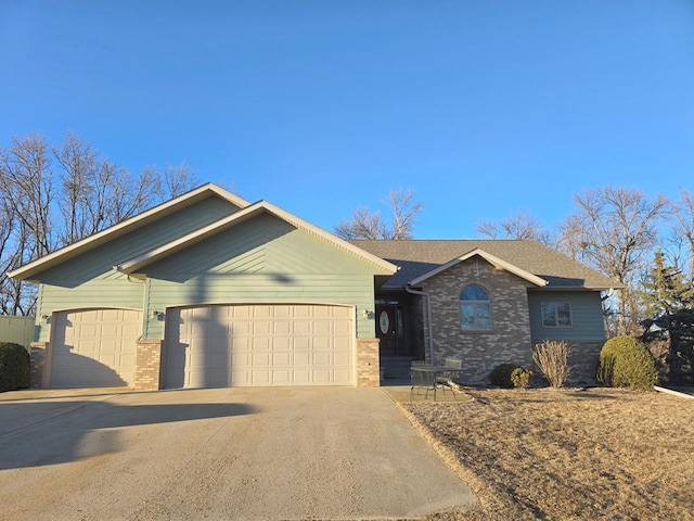 ranch-style house with concrete driveway, brick siding, an attached garage, and roof with shingles