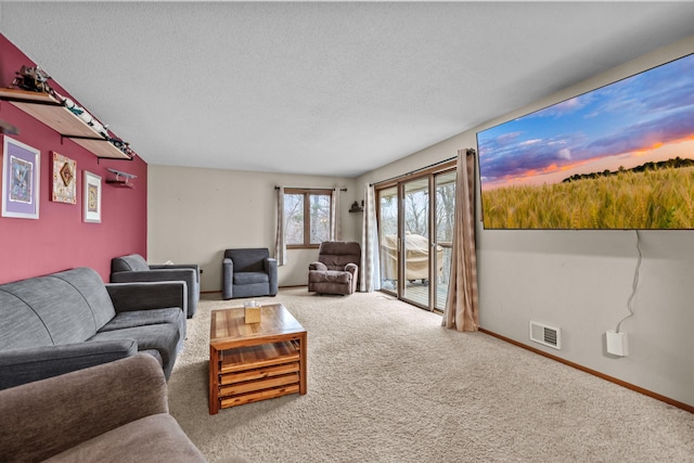 living room featuring visible vents, baseboards, carpet, and a textured ceiling