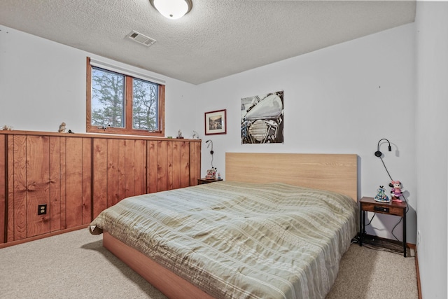 carpeted bedroom featuring visible vents and a textured ceiling