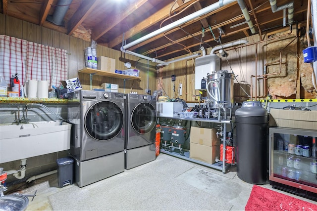 washroom featuring a sink, laundry area, and washer and clothes dryer