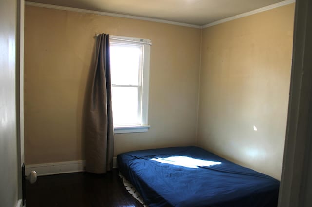 bedroom with dark wood-type flooring and ornamental molding