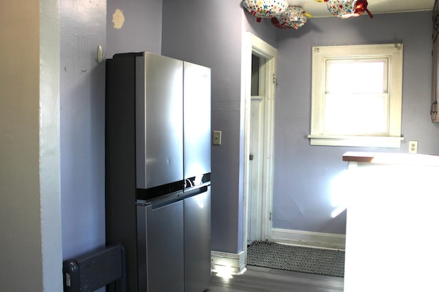 kitchen with wood finished floors, baseboards, and freestanding refrigerator