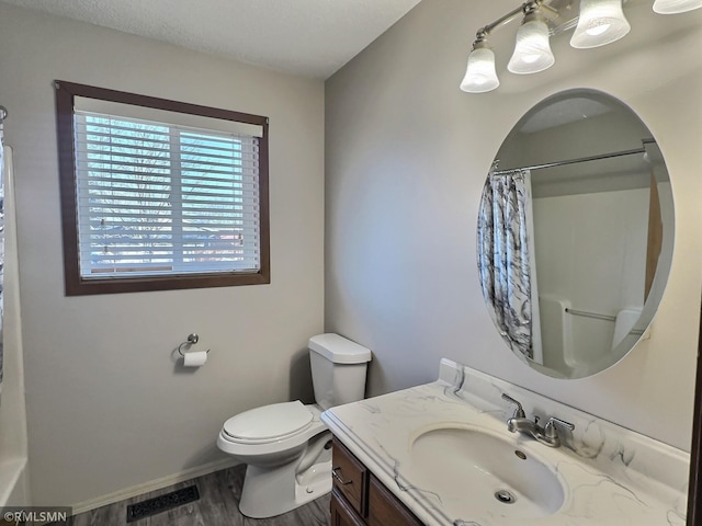 bathroom with visible vents, toilet, a shower with shower curtain, wood finished floors, and vanity