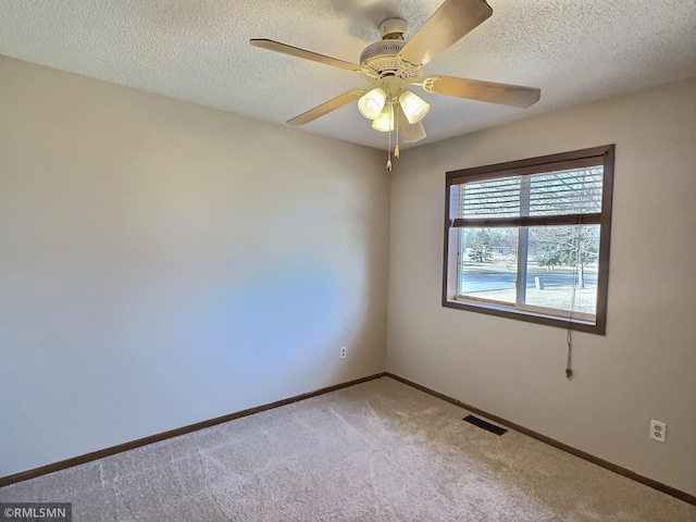 unfurnished room featuring baseboards, visible vents, carpet floors, and a textured ceiling