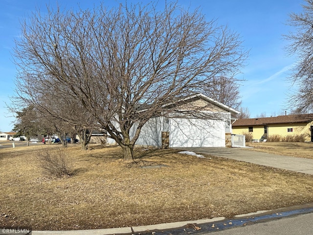 view of side of home with a garage and concrete driveway