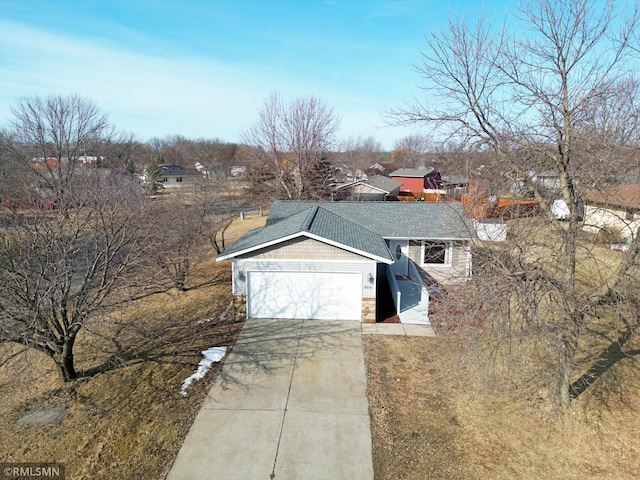 view of front facade with stone siding, concrete driveway, a garage, and a shingled roof