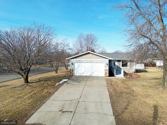 exterior space featuring a front yard, an attached garage, stone siding, and driveway